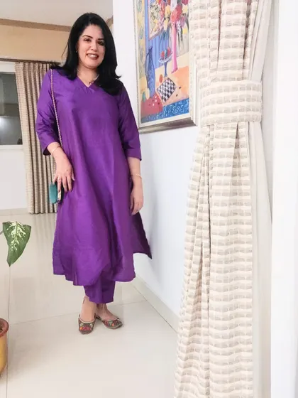 For an anniversary dinner, I chose this bright purple kurta set. The vibrant colour is celebratory, and I paired it with a green bag and juttis for a fun contrast.