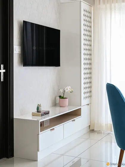 This design cleverly combines a TV unit and a puja unit. The tall cabinet with traditional jali work serves as a discreet and beautiful mandir, perfect for modern homes with limited space.