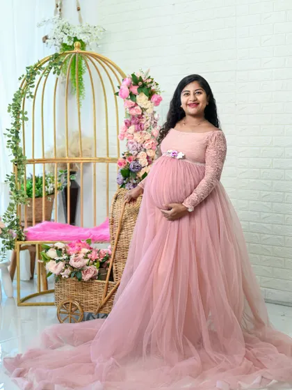 A lovely solo portrait in a flowing pink gown. The floral details and the classic birdcage prop create a very feminine and romantic setting.