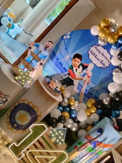 A high-angle shot of the cricket decor, highlighting the personalized backdrop with the birthday boy's photo.
