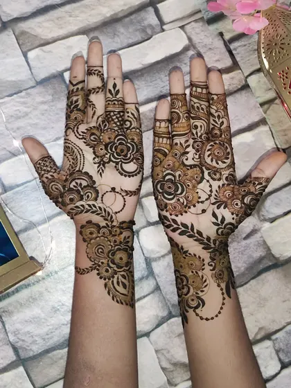 A matching set of floral mehendi for Eid, with complementary designs on each hand.