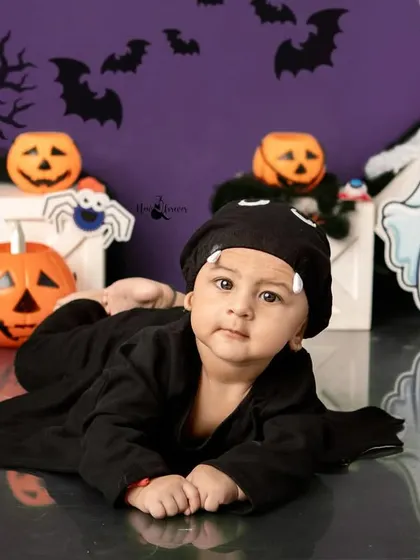 A tiny bat resting among the pumpkins and ghosts. This pose is perfect for younger babies during our Halloween sessions.