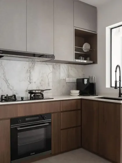 This compact kitchen design proves that small spaces can be highly functional. We used a two-tone approach with wood-finish lower cabinets and light grey upper cabinets to create visual interest, while including an open dish-drying rack for practicality.