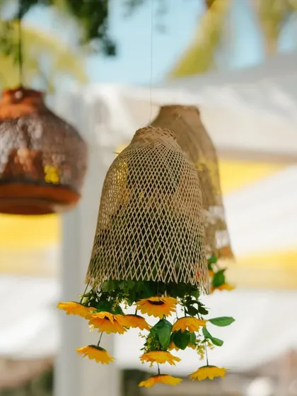 Woven baskets filled with sunflowers hanging from a tree, adding a rustic and charming detail to the Haldi decor.