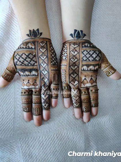 A beautiful and elegant mehendi design chosen by the client. This piece combines geometric grids with tiny elephant figures and is topped with a bold lotus at the wrist.