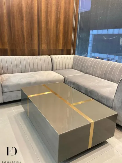A modern L-shaped sofa with channel tufting, paired with a sleek, low-profile coffee table with gold inlay. This setup is perfect for a contemporary office lounge or a minimalist living room.