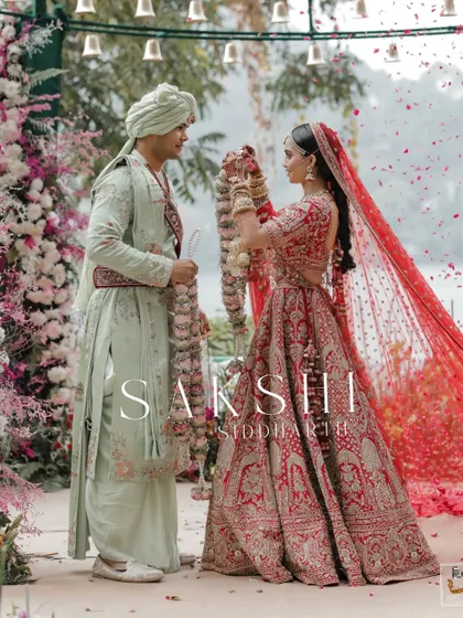 The jaimala ceremony at a stunning lakeside wedding in Naukuchiatal, with flower petals showering the couple.