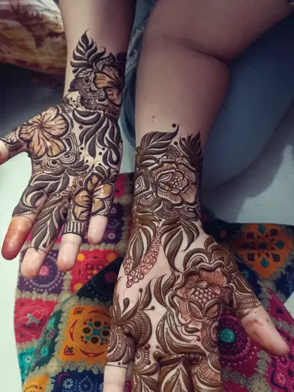 This design features large, open floral patterns on the back of the hands, a hallmark of the Arabic mehendi style. It's an elegant choice for any occasion.