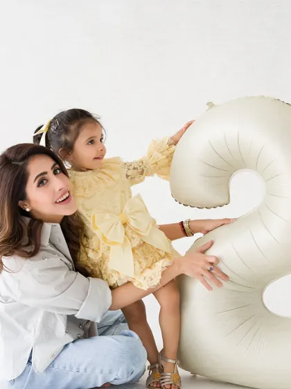 A candid and happy moment between a mother and her daughter during a second birthday photoshoot in the studio.