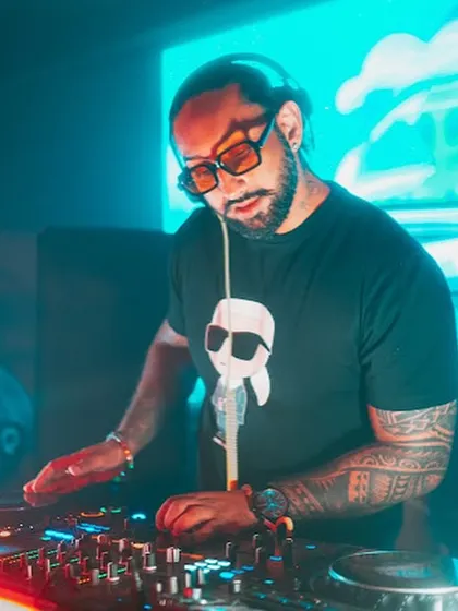 Mixing tracks under the cool blue and orange lights in Kolkata. The right lighting is crucial for setting the mood, and I work with venues to create the perfect vibe.