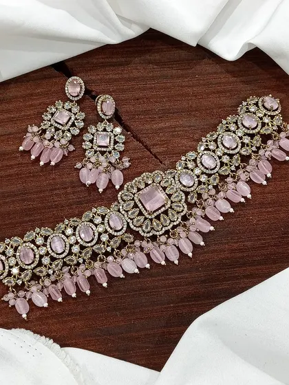 A versatile choker set available in multiple colors including white pearl, ruby, emerald, and pastel pink. The design features a central square motif with hanging beads, making it a popular choice for various festive occasions.