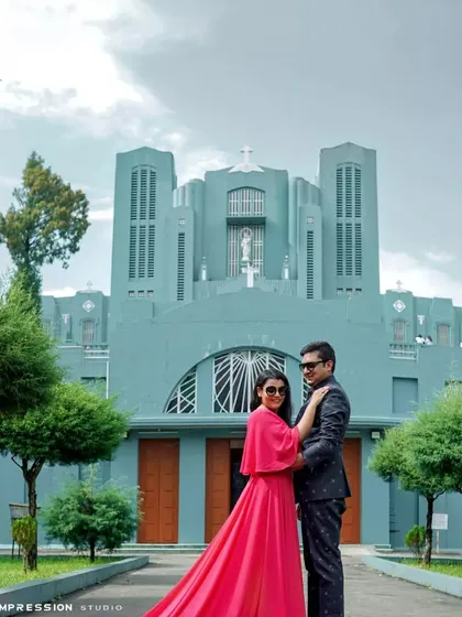 A grand portrait in front of a beautiful church. The vibrant color of her dress against the cool tones of the building creates a striking visual contrast, making for a memorable and stylish pre-wedding photo.