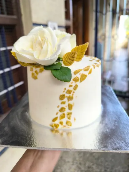 Showcasing a more classic and elegant style, this mini cake features a pristine white finish, a sophisticated gold mosaic pattern, and is topped with delicate, handcrafted sugar paste roses.