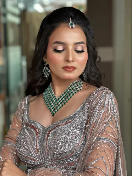 The wavy, open hairstyle complements the soft glam makeup beautifully.