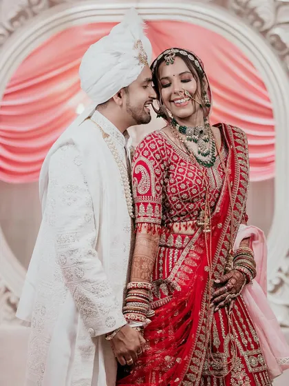 A candid moment of love and laughter, as the groom whispers in his bride's ear, resulting in a beautiful, natural smile.
