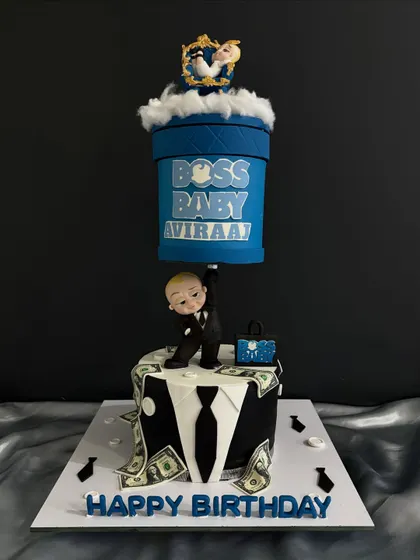 Another angle of the impressive Boss Baby cake, highlighting the hand-sculpted character and the shower of edible dollar bills.