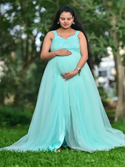This light blue maternity gown is designed with a long, flowing trail to create stunning, ethereal photos. It's made from a lightweight net fabric that drapes beautifully.