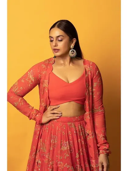 A close-up on the details. The solid orange crop top provides a great contrast to the printed skirt and jacket.