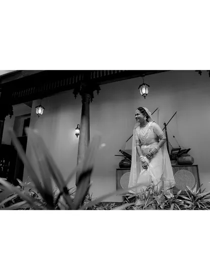 A black and white photo of the bride, capturing a candid moment of laughter and joy in a timeless style.