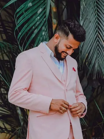 A close-up of our client looking happy and confident in his custom-made pink suit. I love creating unique pieces that reflect my clients' personalities.