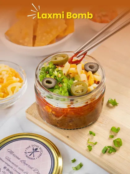 Meet the 'Laxmi Bomb' from our Edible Patakas series. This is our famous Mexican Layered Dip, a flavour explosion that's perfect for your festive celebrations.