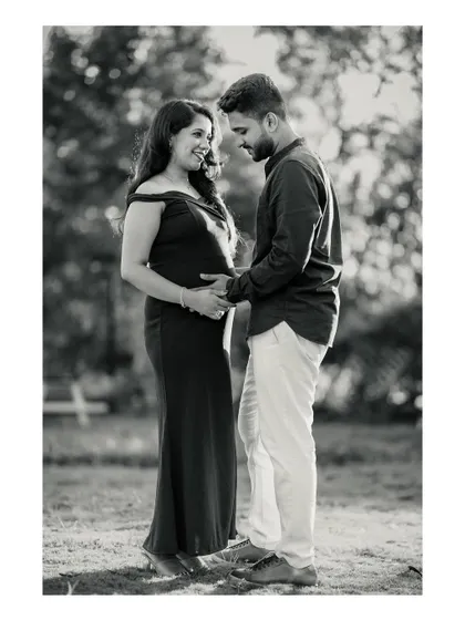 A timeless black and white photo of an expecting couple sharing a quiet, happy moment together outdoors. This classic style emphasizes the emotional connection and anticipation.
