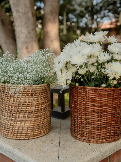 Wicker baskets filled with white chrysanthemums and baby's breath, adding a touch of rustic charm to an elegant event.