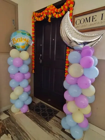 Welcome your guests right from the doorstep. These pastel balloon pillars, topped with a moon and a "Welcome Baby" foil balloon, create a festive entrance for a home-based celebration.