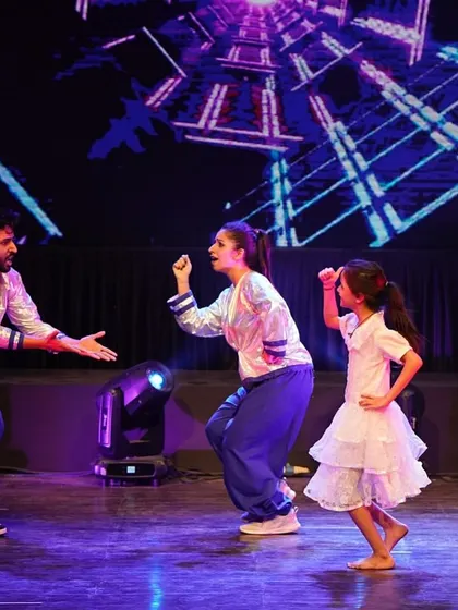 An interactive moment during the Bollywood routine, where dancers engage with each other as part of the choreography.