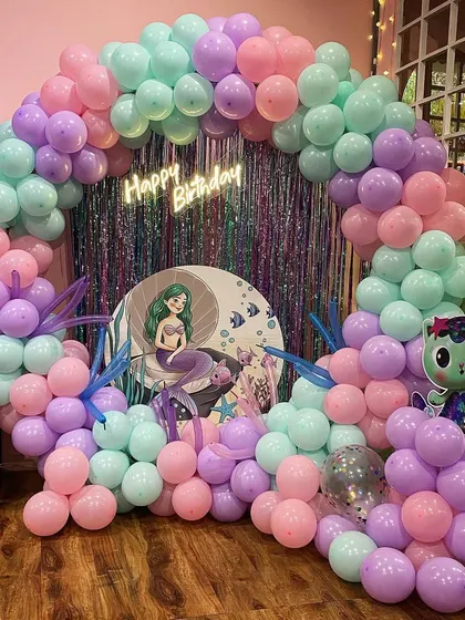 A beautiful pastel mermaid theme, featuring a soft-colored balloon arch and a cute mermaid character backdrop for a dreamy under-the-sea party.