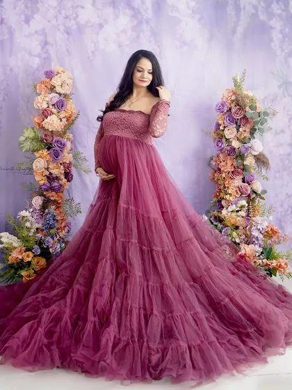 A vision in lavender and mauve. Standing between two floral pillars, the mom-to-be looks serene and beautiful in this pastel-toned portrait.