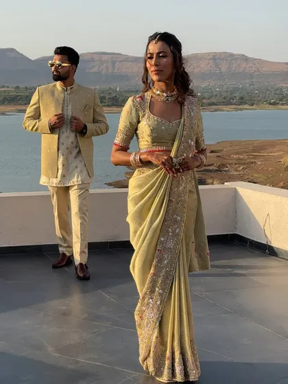 A power couple portrait. The saree is draped to look effortlessly elegant, complementing the groom's classic attire.