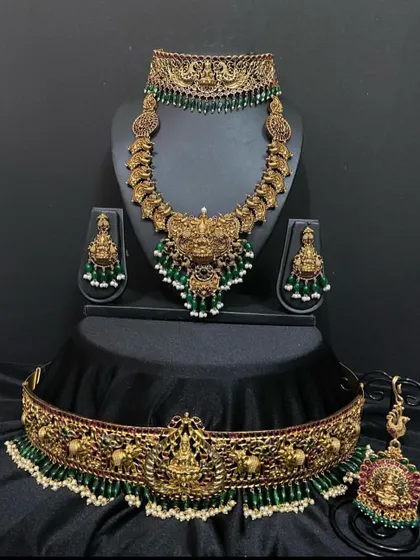 This is a bold Nagas bridal set with a large central pendant. The green beadwork and intricate carvings make this a true statement piece for your wedding.