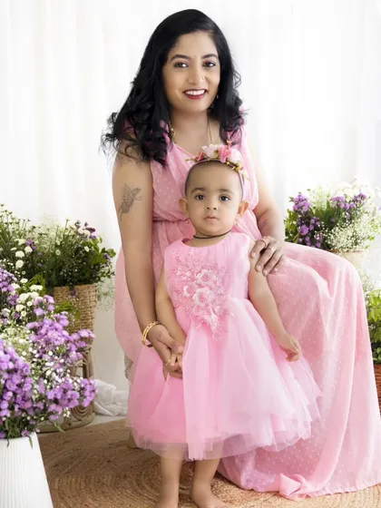 A beautiful standing portrait of a mother and her little girl in their matching pink outfits.