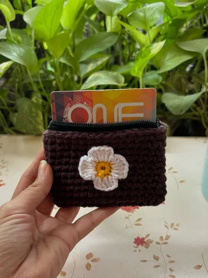 Our mini card wallet held in hand to show its compact size. The flower applique is a lovely detail.