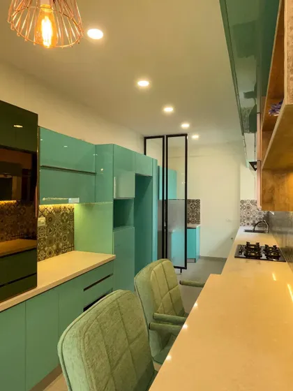 Our execution includes the seamless integration of built-in appliances and custom storage solutions. Here you can see the handleless drawers and cabinets, all finished in a high-gloss laminate for a sleek, modern look.