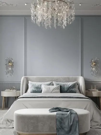 We created a serene and classic atmosphere in this bedroom using a soft blue wall color and elegant wall molding. The crystal chandelier and matching wall sconces add a touch of timeless glamour.