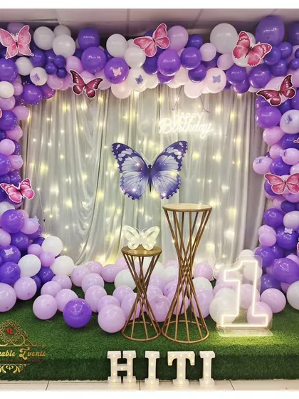Another view of the purple butterfly theme, highlighting the full balloon arch and glowing marquee letters.