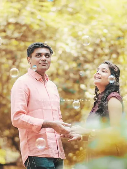 A dreamy, candid shot amidst floating bubbles and golden light. This kind of playful interaction makes for beautiful and natural pre-wedding photos.