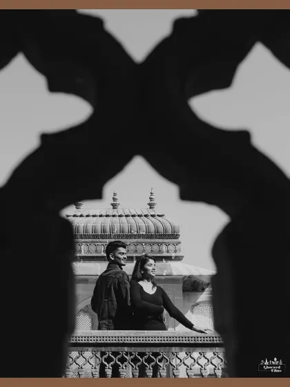 Using architectural elements to create a unique frame. This black and white shot from Vijay Vilas Palace uses the silhouette of a jali archway to frame the couple, adding depth and a sense of timeless elegance.