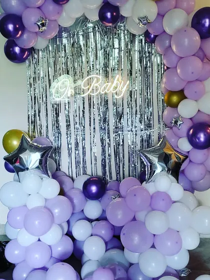 A full view of the purple and white baby shower balloon arch, complete with star-shaped foil balloons for an extra touch of magic.
