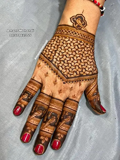 A striking back-of-hand design with a bold, leaf-filled geometric pattern. The fingers are decorated with small bird motifs, adding a delicate touch.
