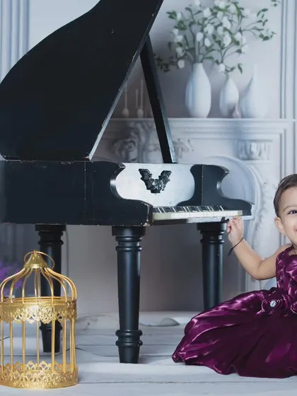 A happy musician posing with her miniature piano and a toy telephone.