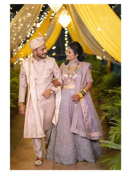 The couple takes a stroll through their beautifully decorated reception venue. This full-length shot showcases their elegant attire and the magical ambiance of the night.
