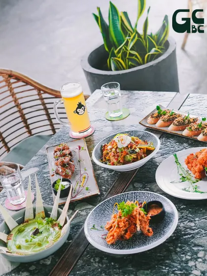 A table set for a perfect brunch, with a variety of appetizers and a cold beer.