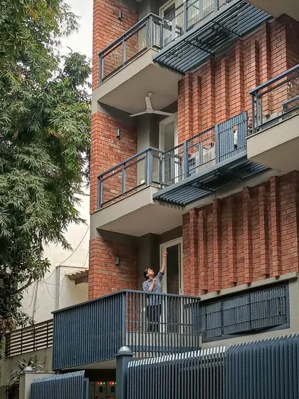 The facade of a residence in Panchsheel, New Delhi, where we used a combination of exposed brick, concrete, and steel. The design includes custom steel fixtures like balconies and screens that are integrated into the building's skin.