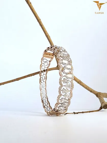 Where pear cut crystals gleam like morning dew and golden filigree curves mirror nature’s own poetry. This elegant diamond bracelet is a timeless classic.