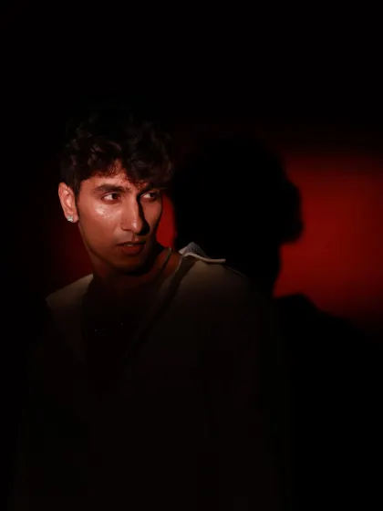 A shot that plays with shadow, casting the model's silhouette against the red-lit background. This adds an artistic and mysterious element to the series.