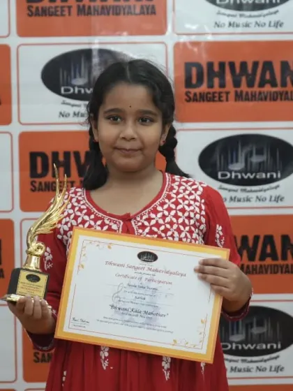 A young student proudly displays her certificate and trophy.