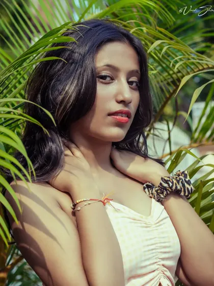 Using natural elements like these palm leaves creates a beautiful frame for a portrait. The bright, direct sunlight gives this shot a vibrant, tropical feel.